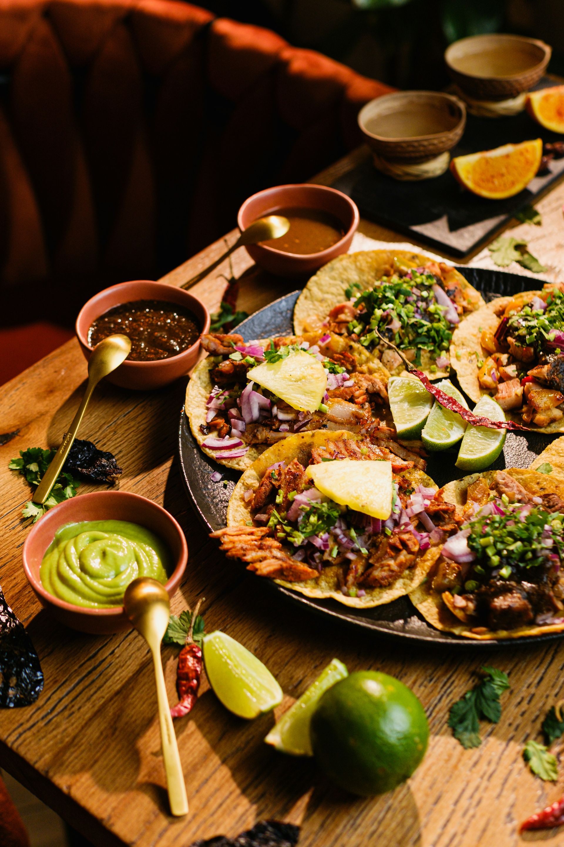 a table topped with plates of food and bowls of salsa